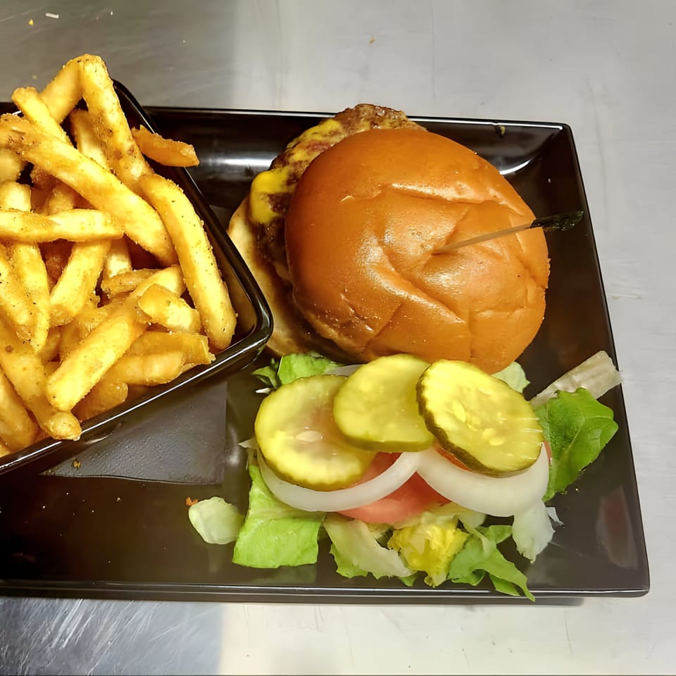 A Crazy Craig's Sports Bar & Grill cheeseburger with fries, lettuce, tomato, onion, and pickles.